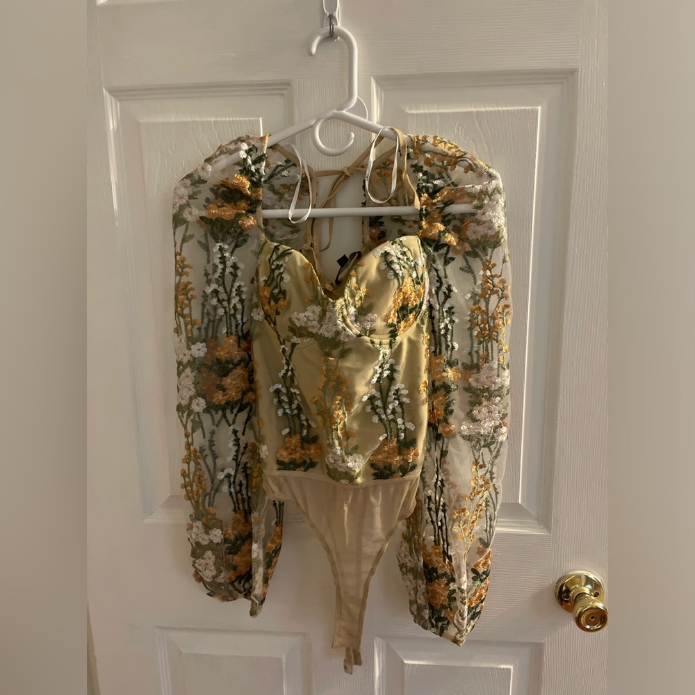 This is a floral body suit top with sea through sleeves!